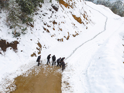 湖北羅田縣蛇家山村村民冒著嚴(yán)寒在鄉(xiāng)村公路上清鏟積雪（1月28日攝）。 　　邱亞林?jǐn)z