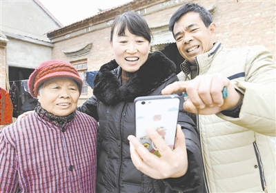 圖為幫扶責任人淮安市漣水縣保灘鎮(zhèn)財政所干部（中）走訪貧困戶，現(xiàn)場打開“陽光扶貧”APP填寫幫扶項目食用菌種植收入信息。曹政 攝